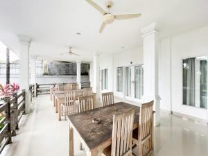 a dining room with a wooden table and chairs at Urbanview Hotel Lilis Ikvala Radha in Canggu