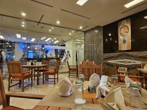 a restaurant with tables and chairs and a clock on the wall at Nehal Hotel in Abu Dhabi