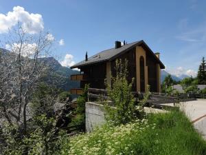 a house on a hill with mountains in the background at Family Stay in Aletsch Alps in Bellwald