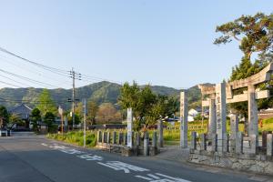 an empty street with a fence on the side of a road at Encounter Dazaifu in Dazaifu