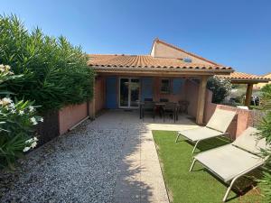 une maison avec un patio aménagé avec deux chaises et une table dans l'établissement Villa T2 à 100m de la plage, piscine, tennis, à Saint Cyprien Plage