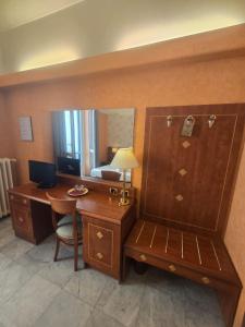a hotel room with a desk and a mirror at Hotel Chelsea in Turin