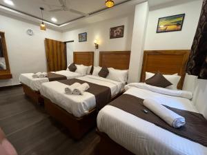 a hotel room with two beds with towels on them at C P Cottage Resort in Mahabaleshwar +56 photos