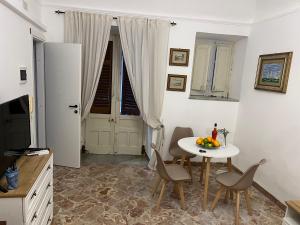 a dining room with a table and chairs and a television at Appartamenti Tiffany & Timi in Carini