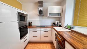 a kitchen with white appliances and a wooden counter top at Ferienwohnung mit Garten am Wald in Barsinghausen