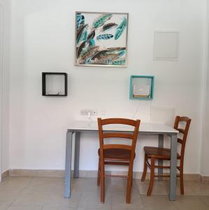 a table with two chairs and a picture on the wall at My Lovely Apt in Tel Aviv