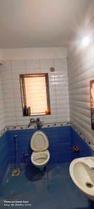 a bathroom with a toilet and a sink at Marigold Bungalow in Kelavli +32 photos