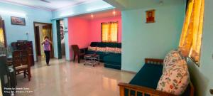 a woman walking through a room with a bedroom at Marigold Bungalow in Kelavli
