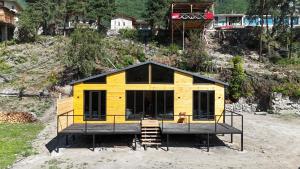 メスティアにあるTetnuldi River Chaletの丘の上に小さな家が建てられている