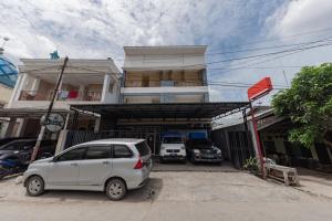 サマリンダにあるRedDoorz at HSP Guest House Samarindaの建物の前に駐車された白い車