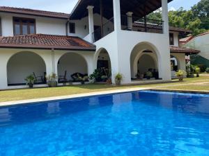 a swimming pool in front of a house at Villa Nilmalee in Gampola