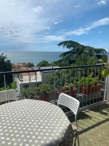 a patio with a table and chairs on a balcony at Affittacamere via Moncolano mare Barcola in Trieste