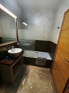 a bathroom with a sink and a bath tub at Adosado cerca del mar con piscina privada in Vinaròs