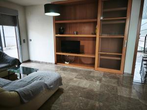 a living room with a couch and a tv at Adosado cerca del mar con piscina privada in Vinaròs
