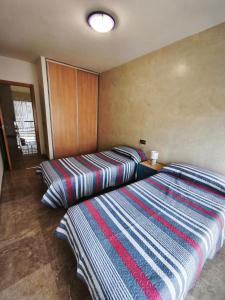 two beds sitting next to each other in a room at Adosado cerca del mar con piscina privada in Vinaròs +28 photos