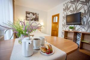 a table with a plate of food and two cups of coffee at Villa Anna - Noclegi Rooms - FREE parking, taras, 1500m do Starówki in Gdańsk