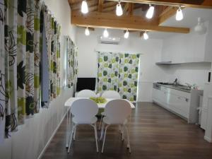 a dining room with white chairs and a table at Rental villa Yukura Nakijin near Janglia Okinawa and Churaumi Aquarium in Nakijin +5 photos
