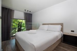 ラワイビーチにあるZen Loft with Private Terrace UTL B118の大きな白いベッドと窓のある寝室 +14枚の写真