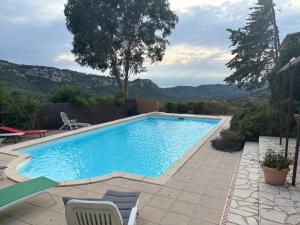 a swimming pool with chairs and a view of mountains at Mas provençal avec piscine privée proche Bandol in Évenos