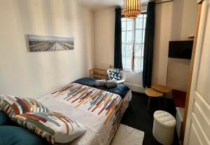 a bedroom with a bed and a chair in it at Mer & Côte Fleurie Plage à pied in Merville-Franceville-Plage