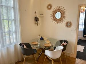 a dining room with a glass table and chairs at Mer & Côte Fleurie Plage à pied in Merville-Franceville-Plage