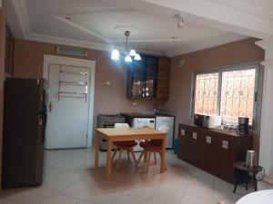 a kitchen with a wooden table and a table and chairs at Résidence Wendyna in Ouagadougou