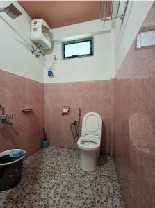 a bathroom with a toilet and a sink and a window at Valley View Homestay in Cherrapunji