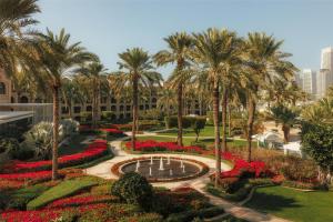 a view of a park with palm trees and a fountain at One&Only Royal Mirage Resort Dubai in Dubai