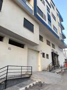 un gran edificio blanco con una raya azul en Appartement 50 m Ocean, en Kenitra