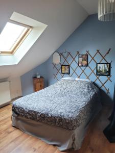 a bedroom with a bed with a blue wall at Chambre chez Manue in Le Mans