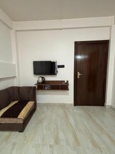 a living room with a couch and a flat screen tv at Kerphida B&B in Shillong