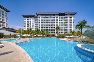 a swimming pool in front of a large building at Begonia Hotel in Sanya