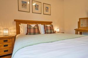 une chambre avec un grand lit blanc avec deux oreillers dans l'établissement Finest Retreats - Westhills Cottage, à Winster