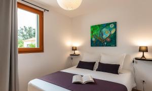 a bedroom with a bed with two books on it at Locations "ChezChristine Aléria" à Aléria in Aléria