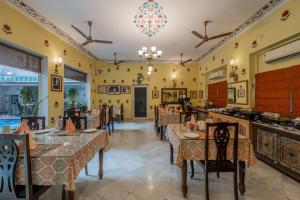 ジャイプールにあるSuryaa Villa - A Boutique Heritage Hotelのテーブルと椅子とシャンデリアのあるダイニングルーム