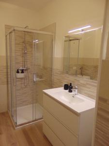 a bathroom with a glass shower and a sink at Torre 2 in Longarone