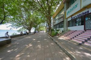 a sidewalk in front of a building next to the water at BayView Retreat Premium Stay at Marine Drive Kochi in Cochin