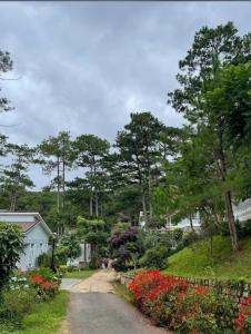 a dirt road with flowers on the side of a house at Lan anh Village - Luxury villa Tuyen lam lake view in Xuan An