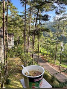 a cup of coffee sitting on a table with a view at Lan anh Village - Luxury villa Tuyen lam lake view in Xuan An
