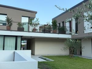 un edificio de apartamentos con balcón con macetas en Appartamento VINESSA - Residence OLIVEA, en Riva del Garda