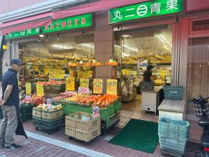 a man walking in front of a market with fruits and vegetables at Great access to Shibuya Big supermarket nearby in Wada