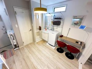 a bathroom with a sink and red chairs in a room at Great access to Shibuya Big supermarket nearby in Wada
