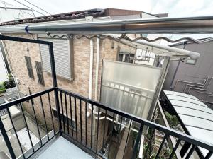 a balcony with a black railing and a building at Great access to Shibuya Big supermarket nearby in Wada