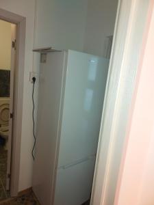 einen weißen Kühlschrank in einem Zimmer neben einer Tür in der Unterkunft Amy&Domy in Iscroni
