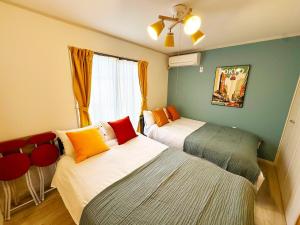 a bedroom with two beds and a window at Great access to Shibuya Big supermarket nearby in Wada