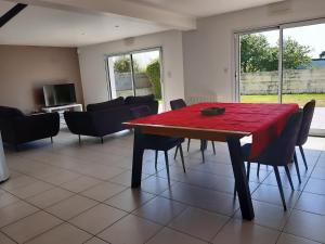 a dining room with a red table and chairs at VILLA SPACIEUSE en bord de mer in Ploemeur