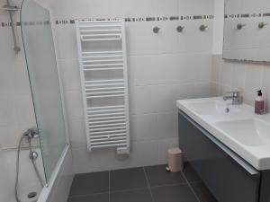 a white bathroom with a sink and a shower at VILLA SPACIEUSE en bord de mer in Ploemeur +11 photos