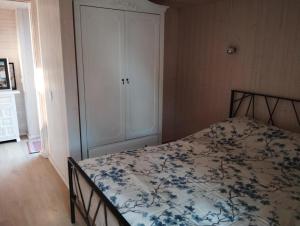 a bedroom with a bed with a floral bedspread at Namelis soduose in Akademija