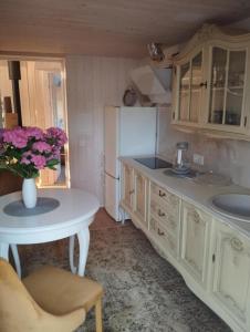 a kitchen with a table and a white refrigerator at Namelis soduose in Akademija