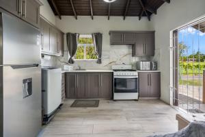 a kitchen with brown cabinets and white appliances at Serene Escape - Central & Modern in Christ Church